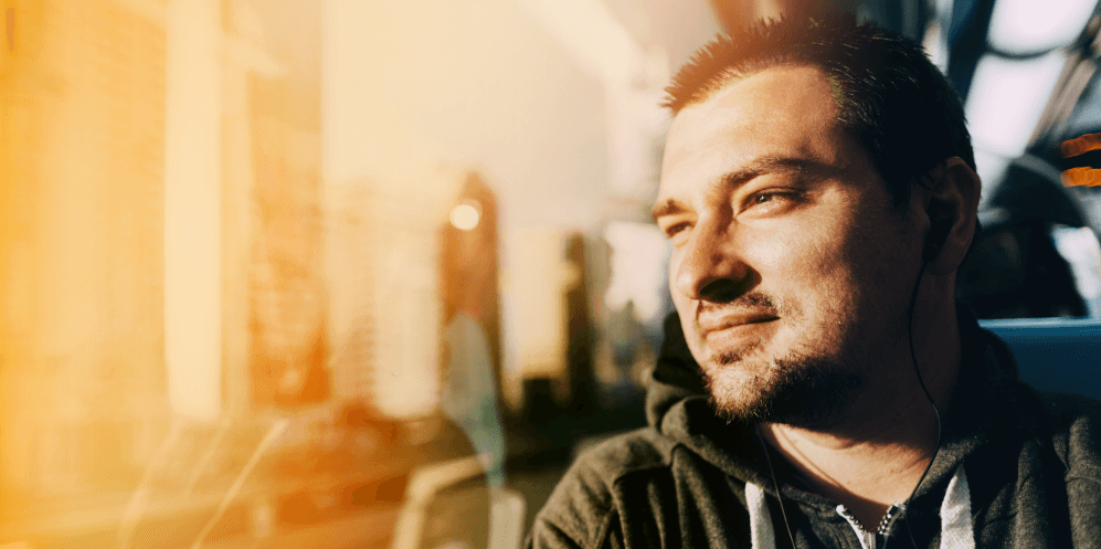 Mental health support for people impacted by transport or workplace incidents. Image shows a reflective man looking out the window on public transport.